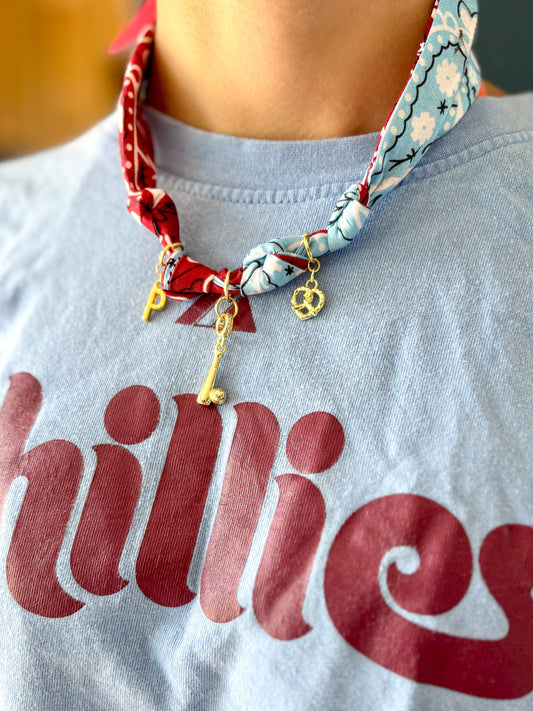 Person wearing a light blue shirt with 'Phillies' text and a colorful scarf around their neck.